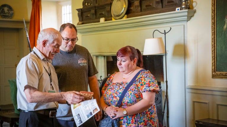A volunteer talks to visitors at Benthall Hall